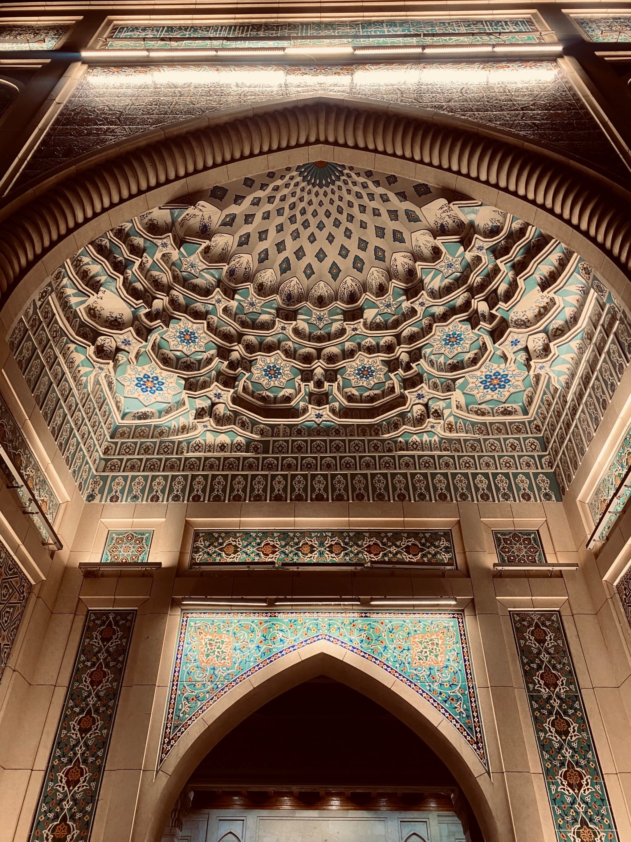 An intricately designed arched doorway, illuminated by warm, golden light, evokes a sense of ancient grandeur and detailed craftsmanship