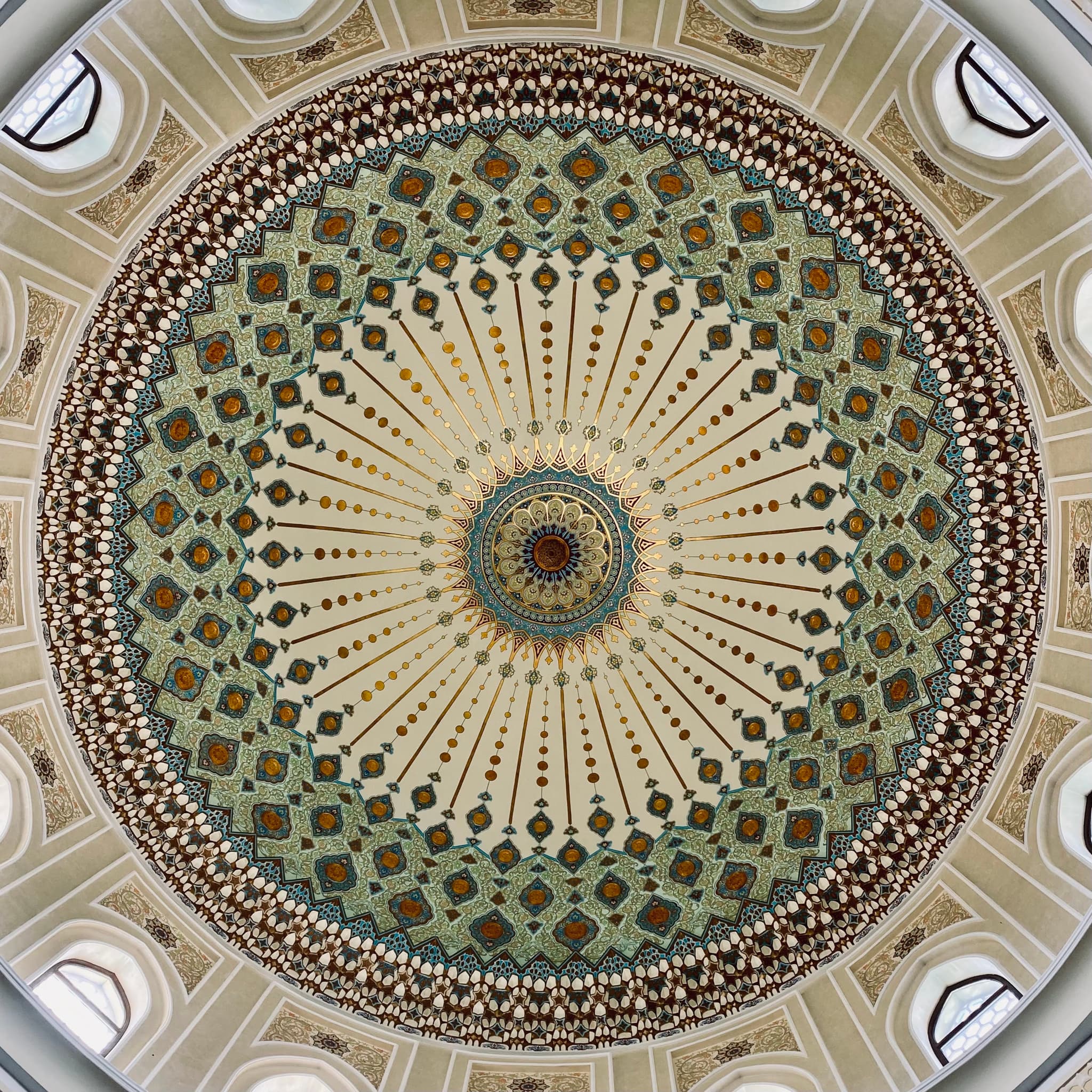 Gorgeous Islamic dome ceiling with intricate mosaic patterns and warm, golden light, creating a serene, spiritual atmosphere