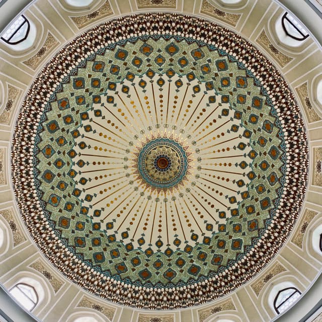 Gorgeous Islamic dome ceiling with intricate mosaic patterns and warm, golden light, creating a serene, spiritual atmosphere
