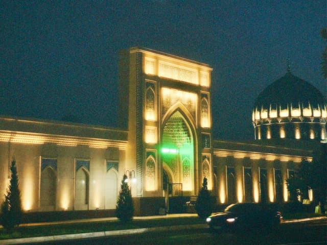 Elegant night scene of a mosque with illuminated arches and green light, serene atmosphere